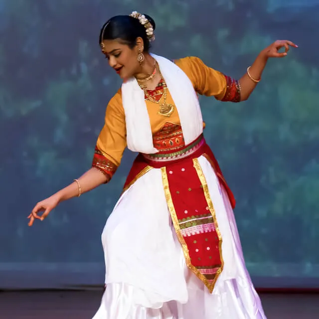 An intermediate Elite dancer in ivory and red, mid-turn