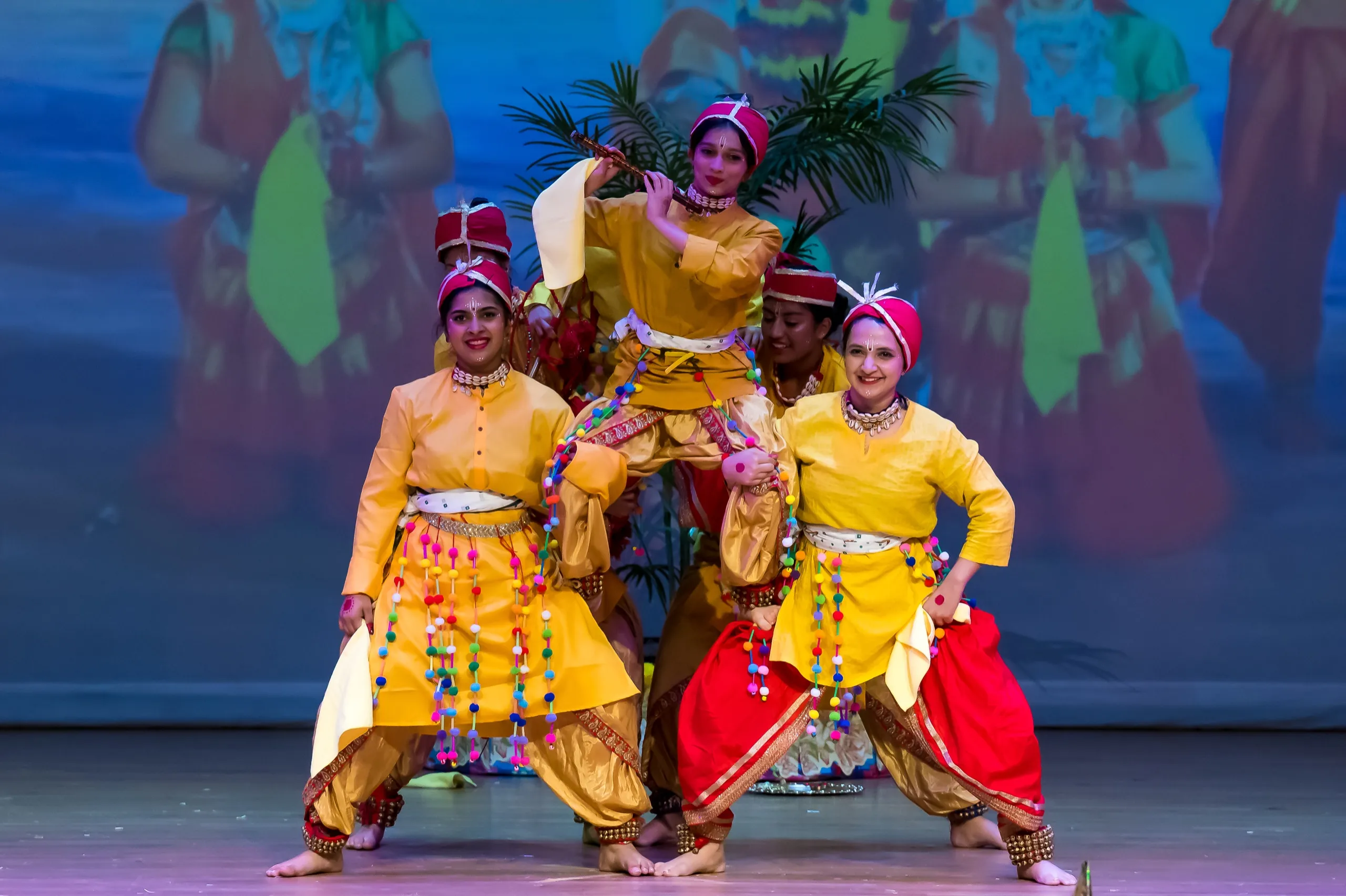NSDA Elite dancers in yellow and red, posed together on stage