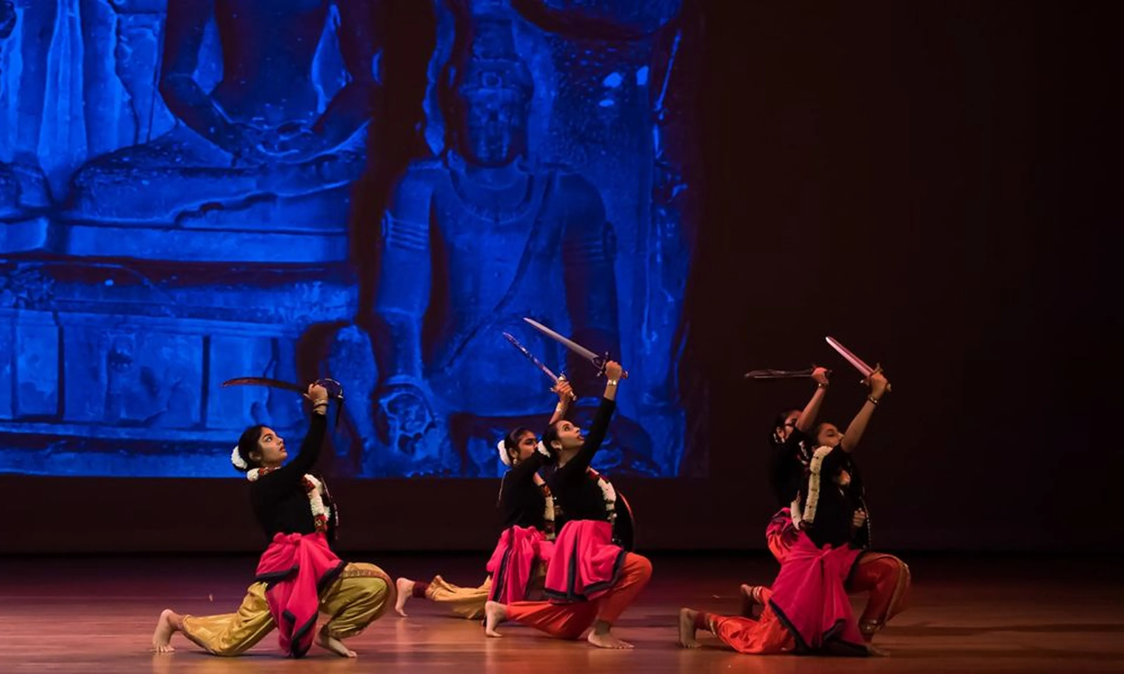 NSDA dancers kneeling with raised swords on stage