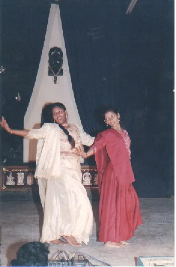 Two dancers on an early NSDA stage, one in ivory and one in deep red