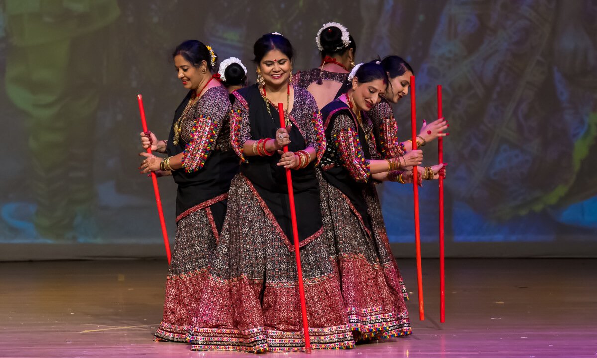 NSDA students standing in formation on stage with decorative sticks.