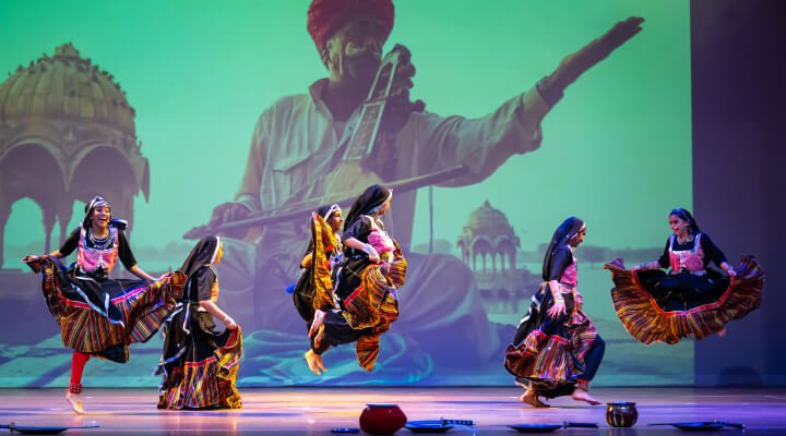 NSDA students performing energetic Kalbelia dance on stage.