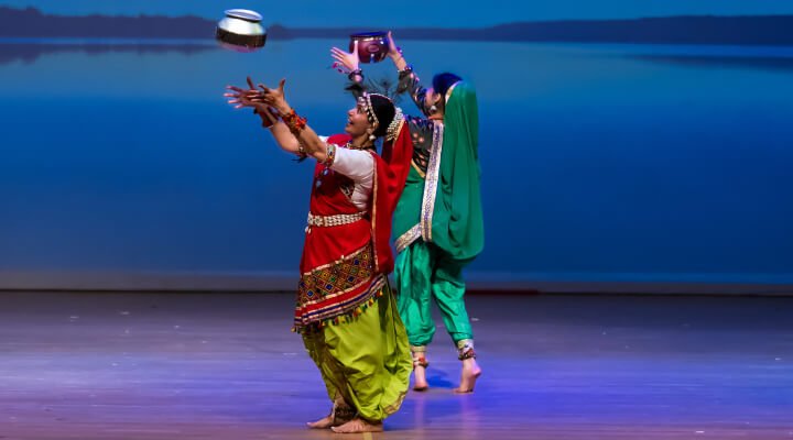 Dancers throw a pot up in the air during a Rathwa dance performance.